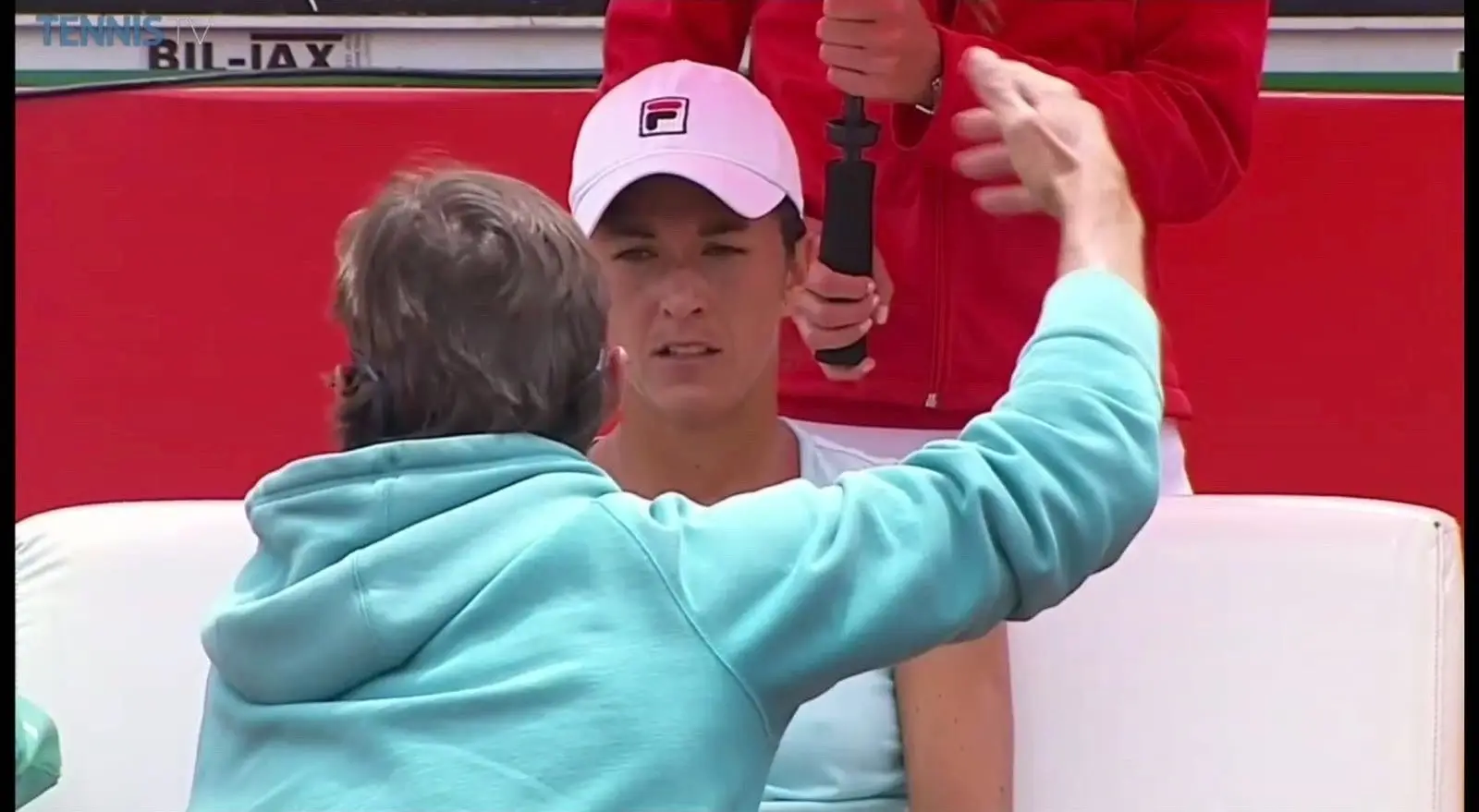 Jérôme Adamec da indicaciones a su jugadora durante un cambio de lado en un partido WTA