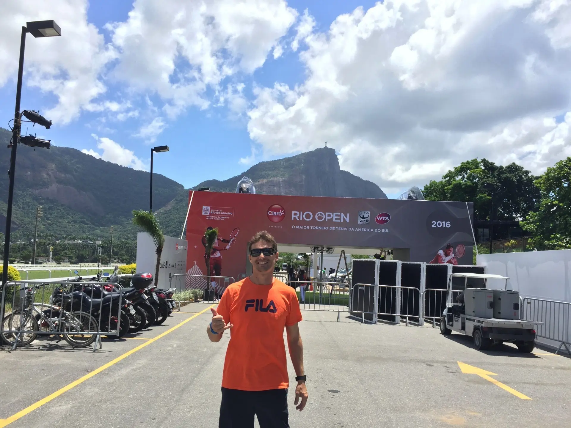Jérôme Adamec devant l'entrée d'un tournoi, montagnes au fond