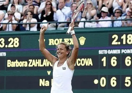 Barbora Strýcová lève les bras devant le tableau d'affichage après sa victoire contre Na Li à Wimbledon